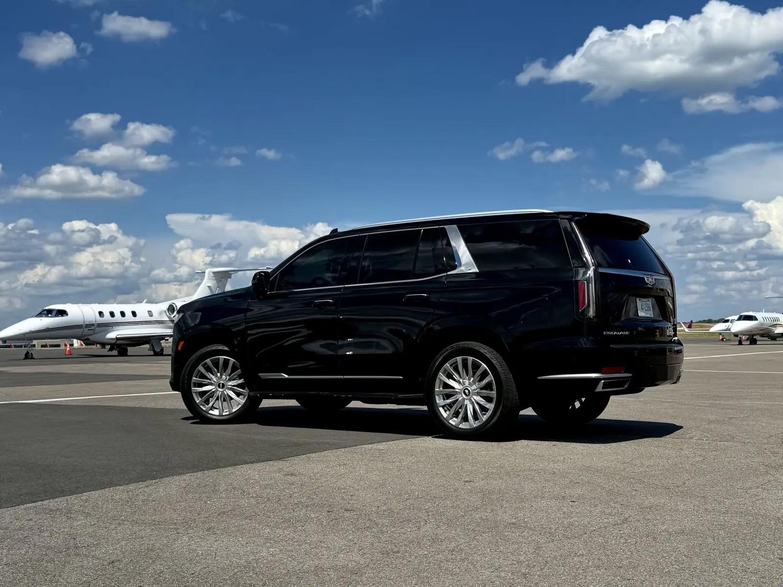 Black Escalade beside a private jet at a Nashville FBO for airport transfers