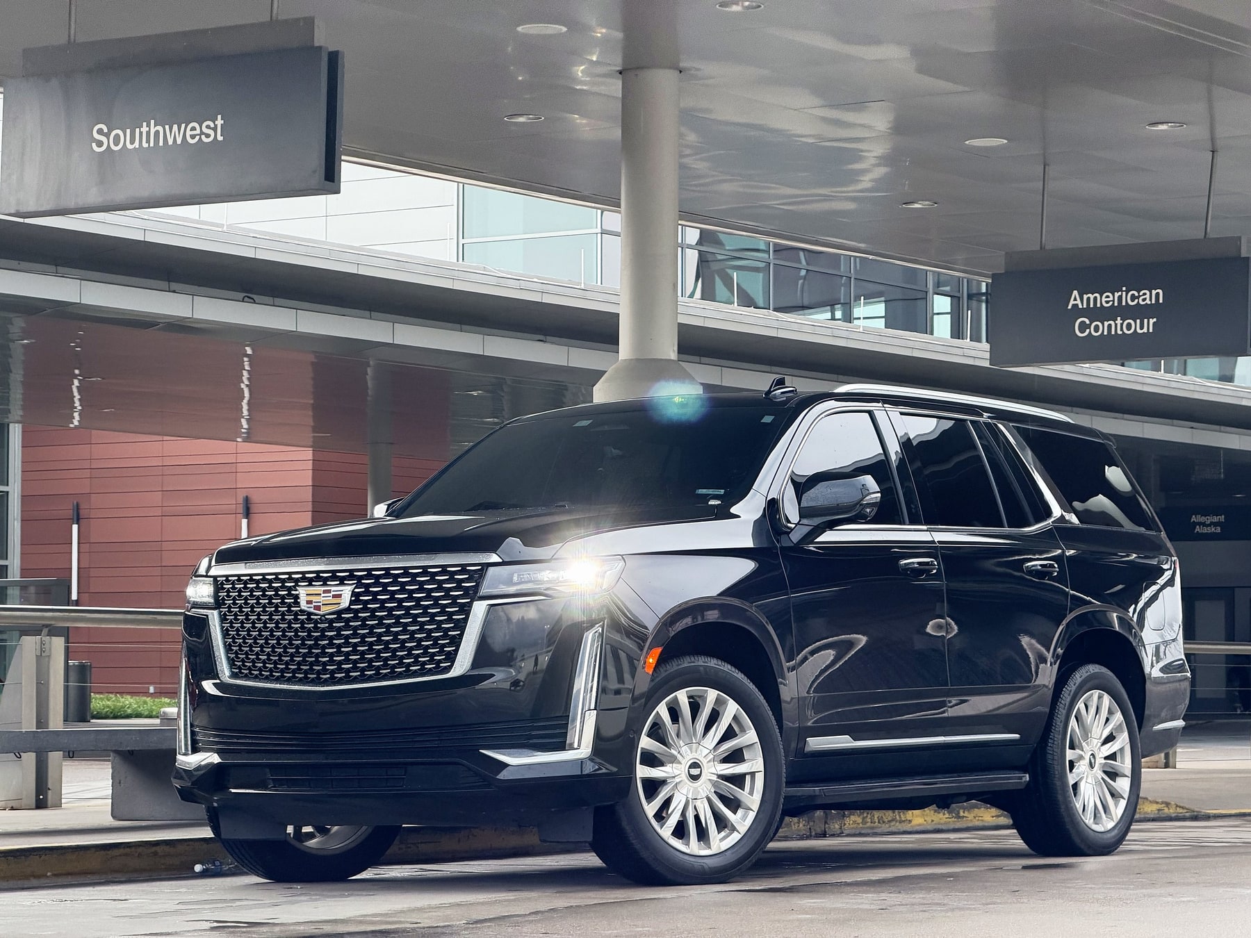Cadillac Escalade with headlights on at BNA departures curbside in Nashville
