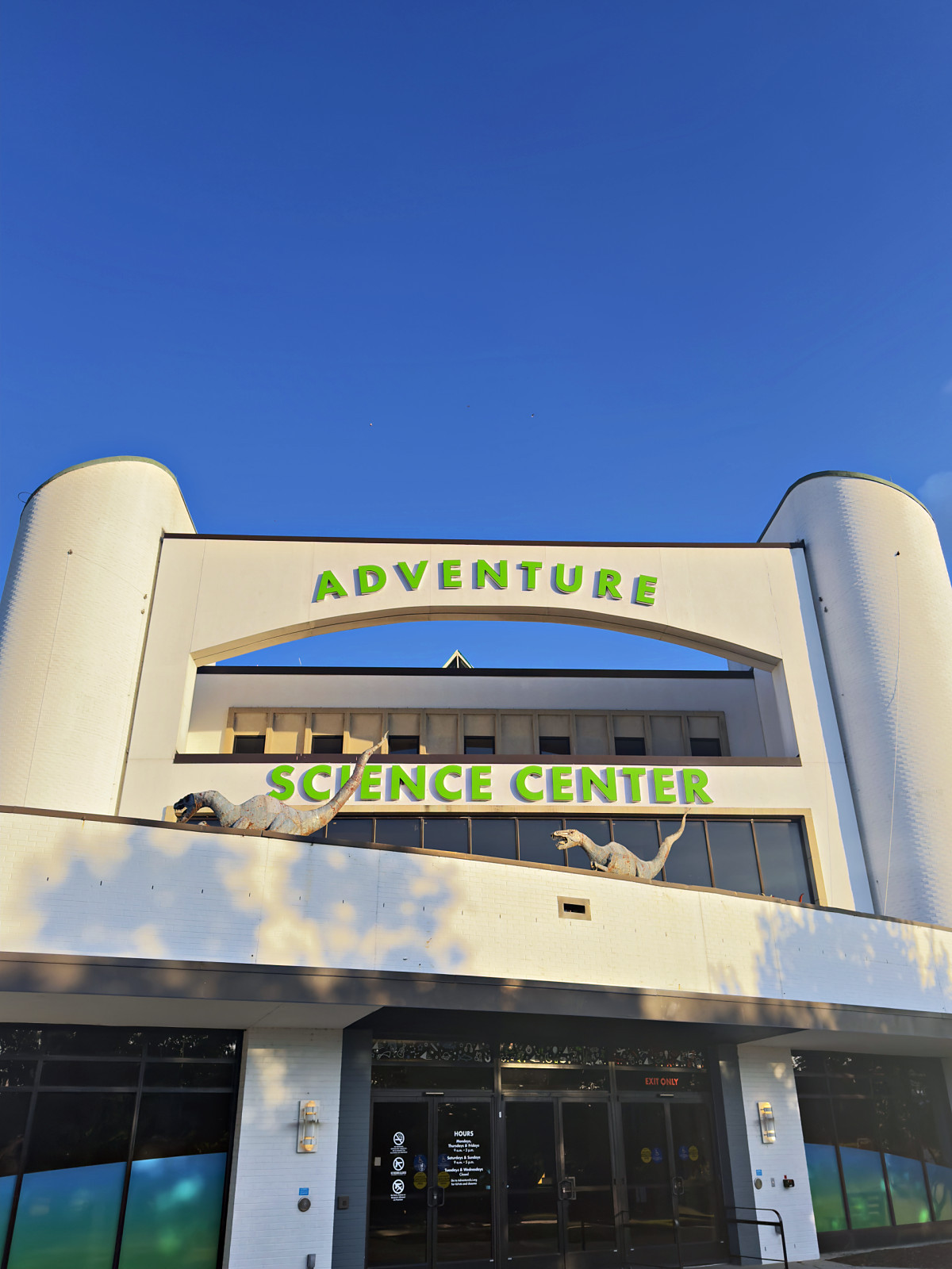 The curved white entrance arch of the Adventure Science Center against a deep blue sky in Nashville