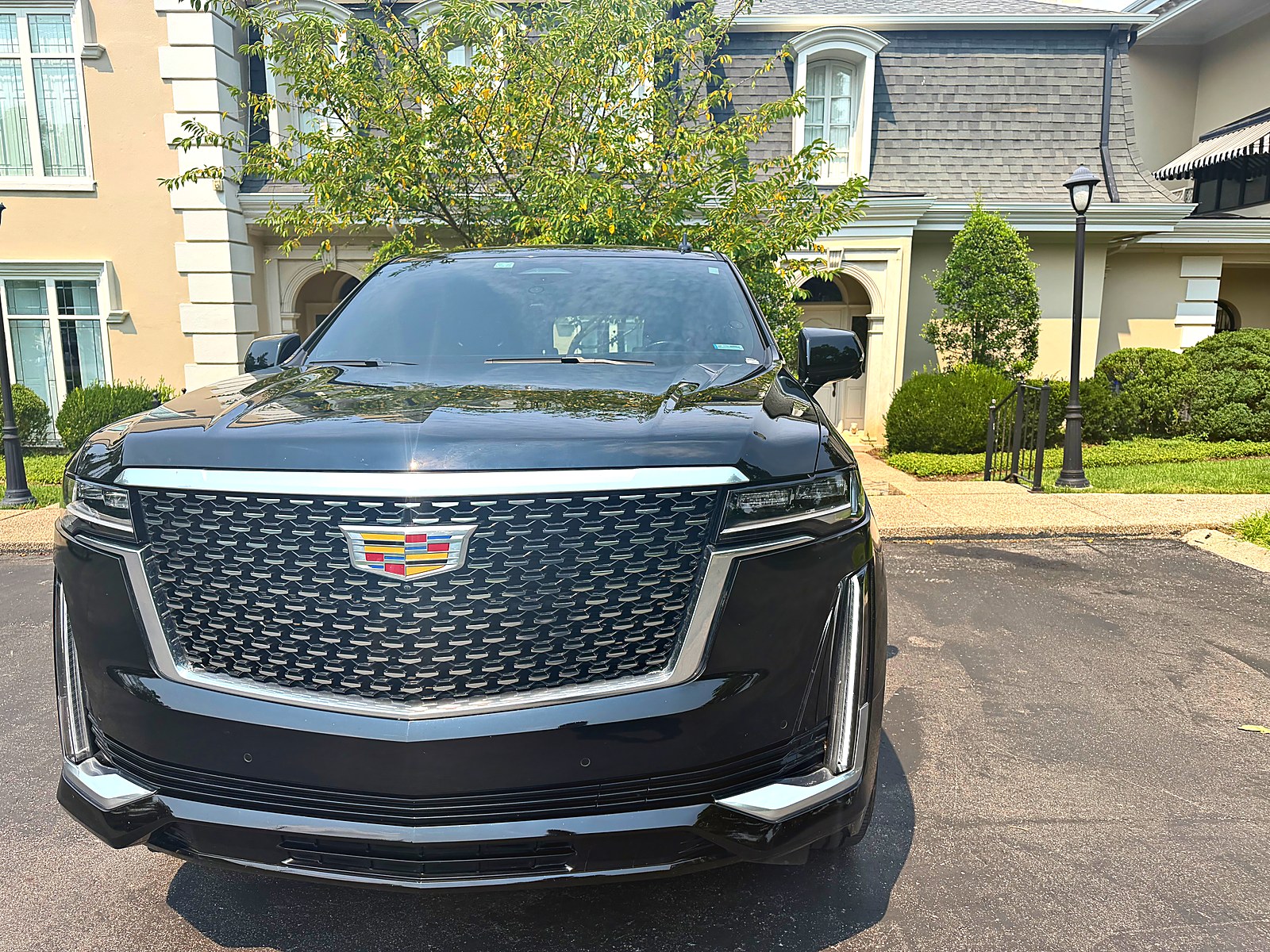 Black Cadillac Escalade waiting outside a French-style residence for a Belle Meade pickup