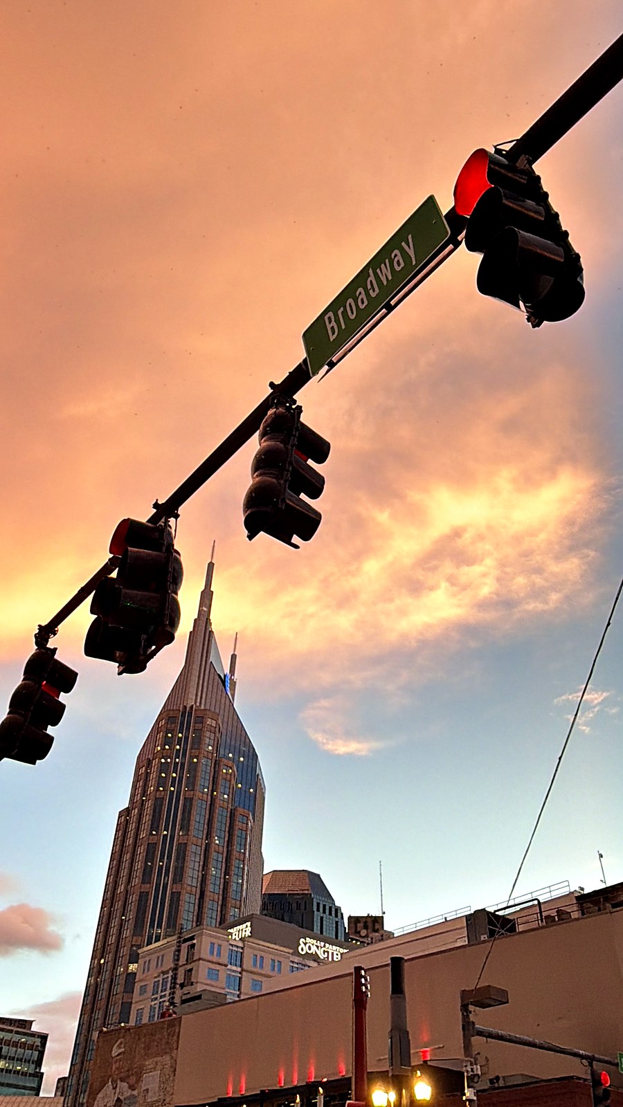 Broadway street sign and the AT and T Building against sunset clouds in downtown Nashville