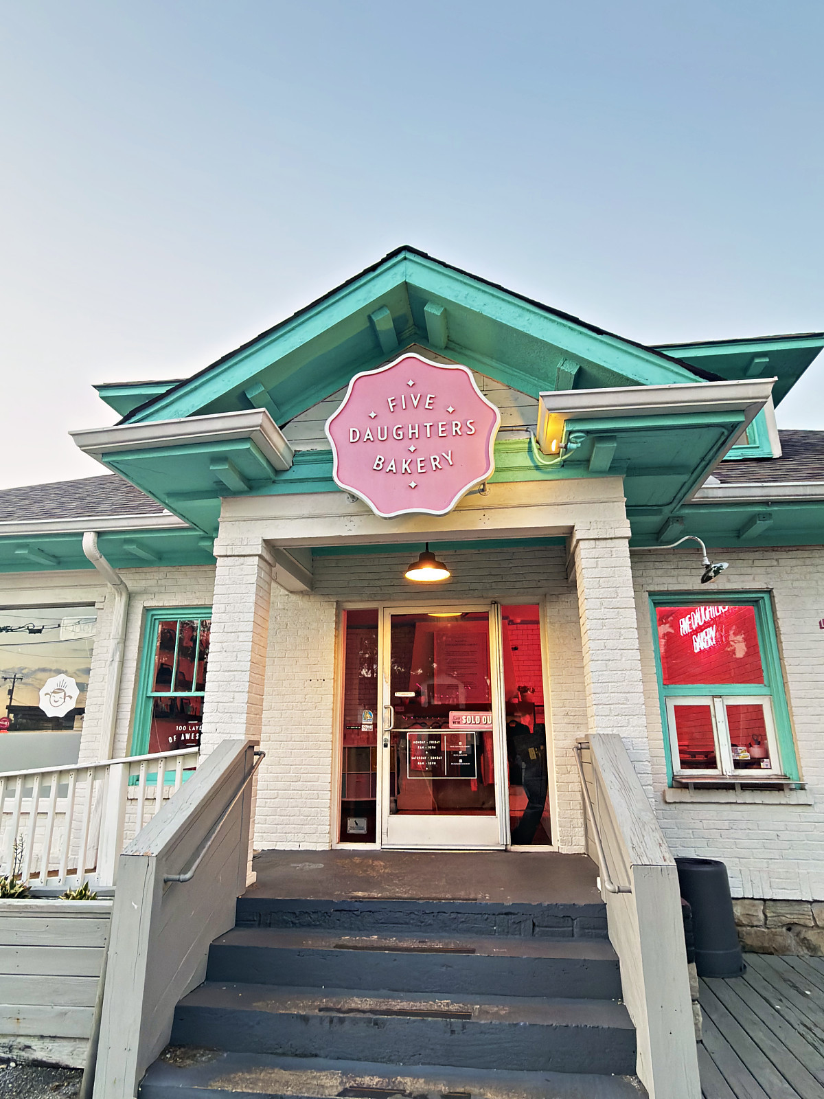 Five Daughters Bakery entrance with mint green trim and a pink sign in 12 South, Nashville