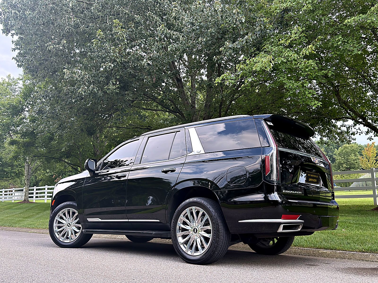 Cadillac Escalade beside a white-fence horse farm near Franklin TN — My Nashville Driver