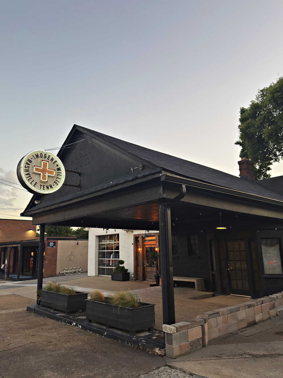 Imogene + Willie denim shop with its round sign under a black gabled roof in 12 South, Nashville
