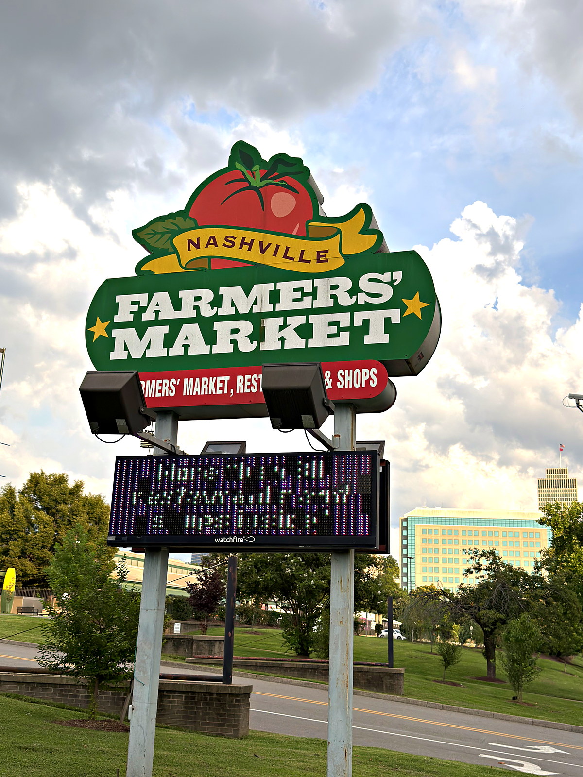 The Nashville Farmers’ Market sign and marquee on Rosa L. Parks Boulevard in Germantown, with the downtown skyline behind