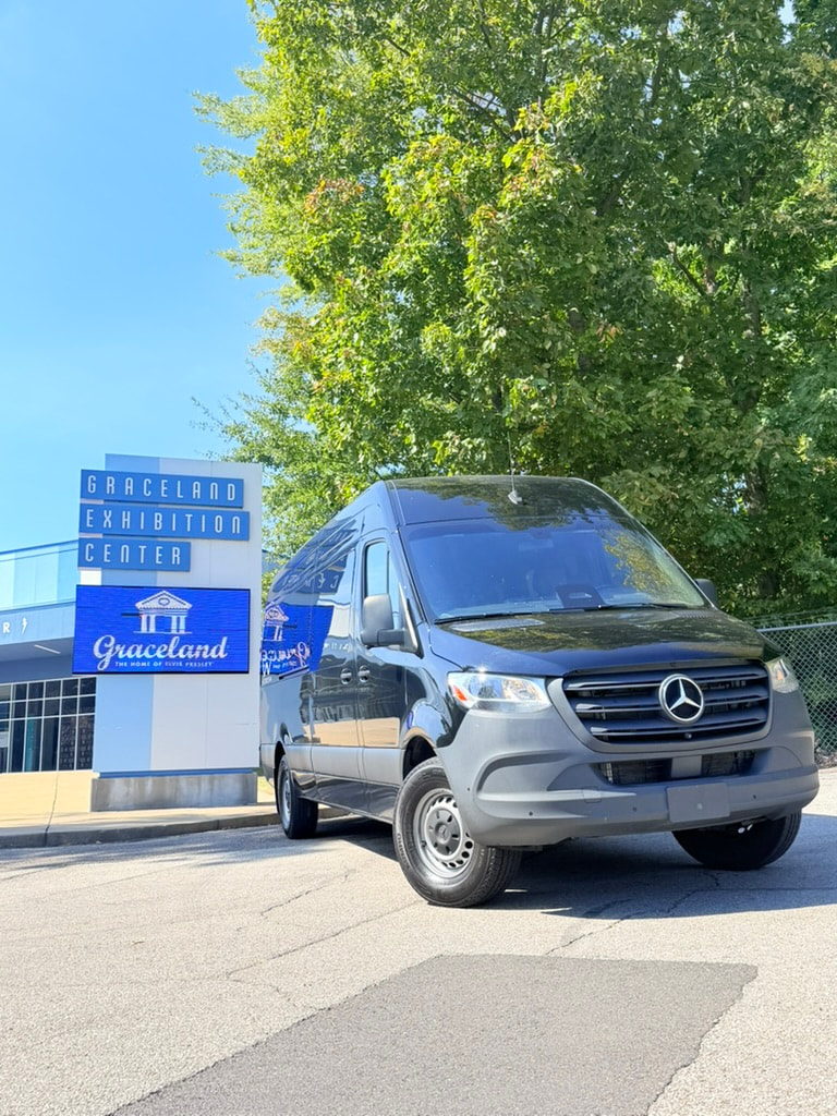Gray Mercedes-Benz Sprinter beside the Graceland Exhibition Center sign in Memphis